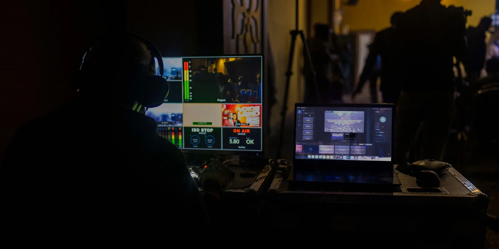 A volunteer in headphones runs the livestream while a laptop beside him keeps the slides going on its own with Verse Copilot